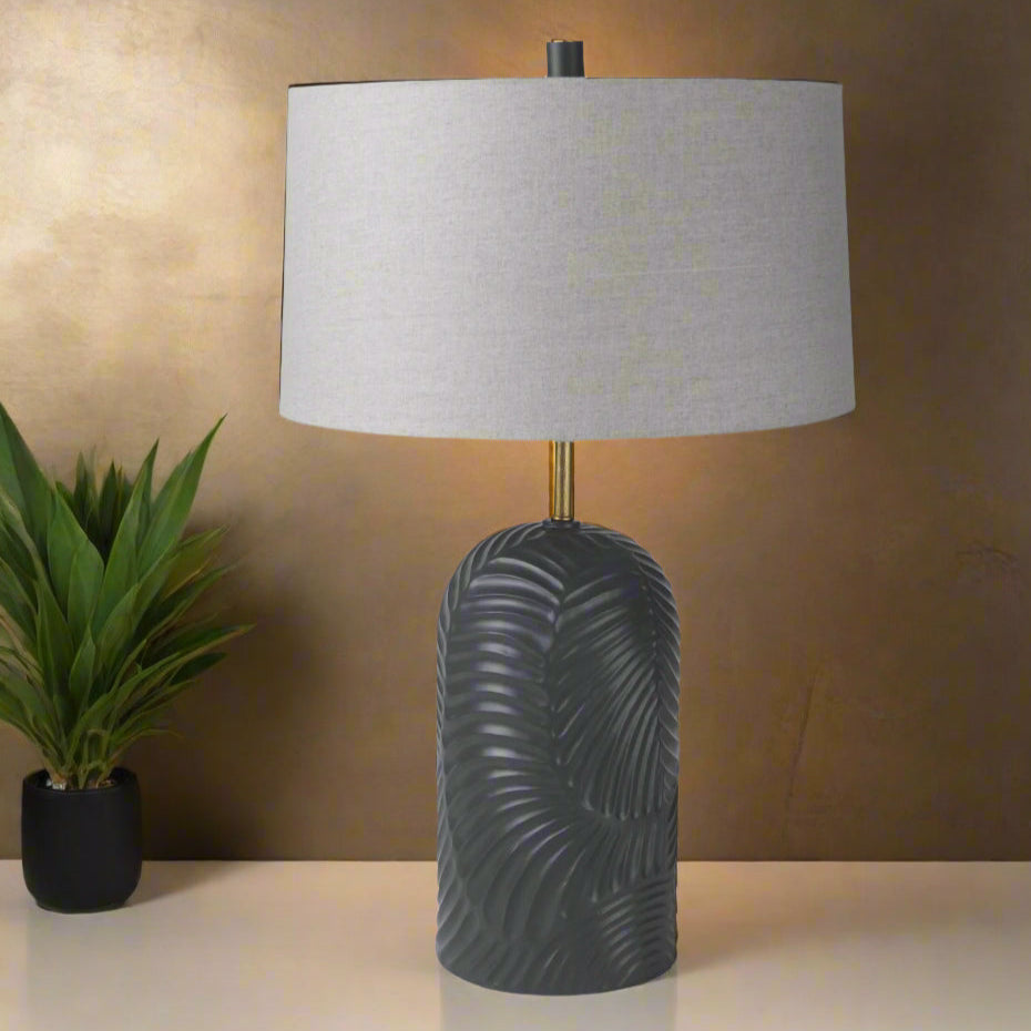 Table lamp with textured dark base and gray shade on a white background